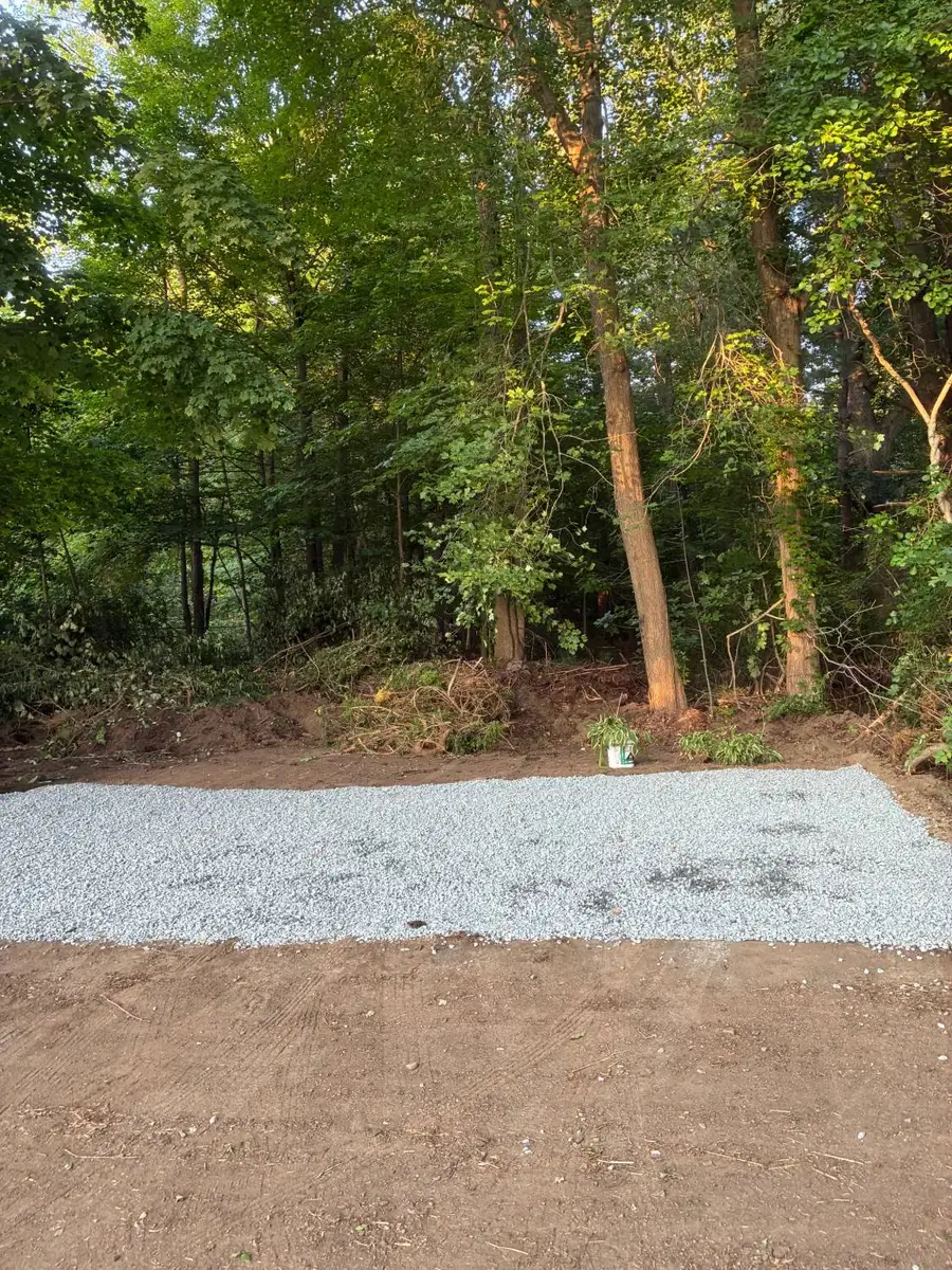After: debris hauled away and a level gravel pad laid at the same spot